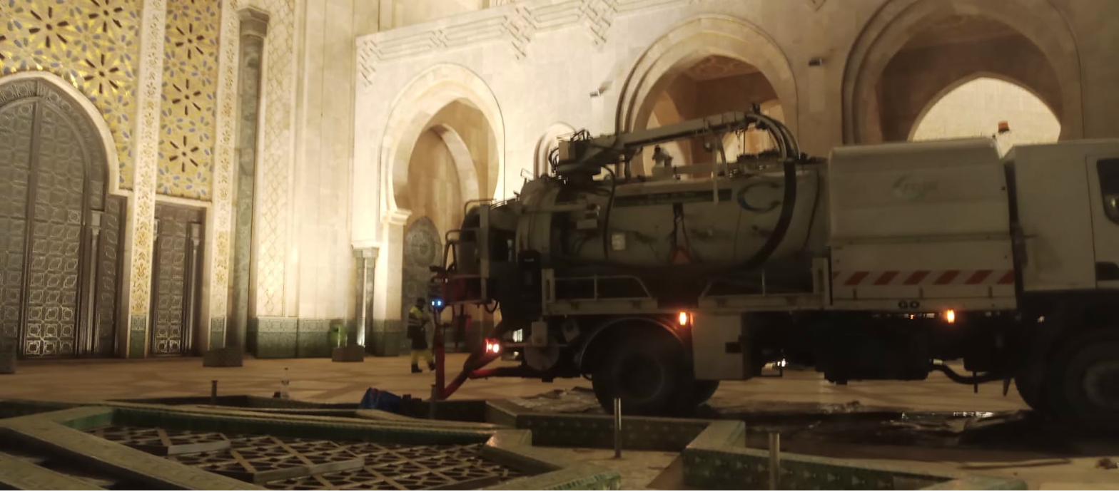 Minaret de la Mosquée Hassan II illuminé, camion de pompage Maroblast en premier plan, intervention nocturne